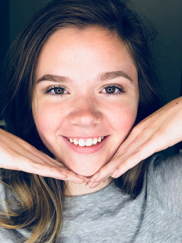 Girl smiling with hands on her cheeks